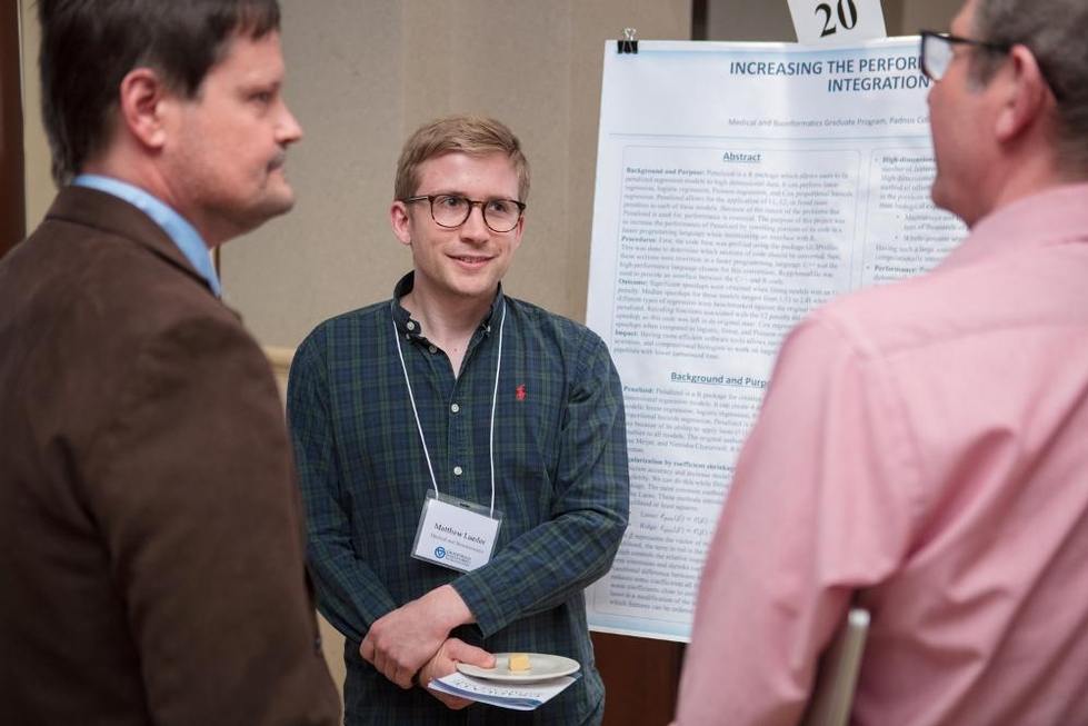 Student presenting research poster to audience